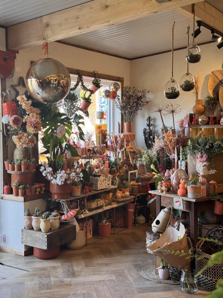 Photo de l'intérieur de la boutique de fleuriste à Arches. On y voit des fleurs, des plantes, de la décoration...