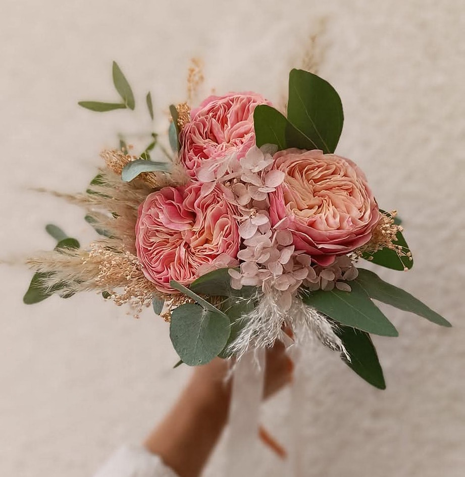 Un magnifique bouquet de mariée bohème composé de roses anglaises roses, eucalyptus, hortensias séchés et graminées pampa