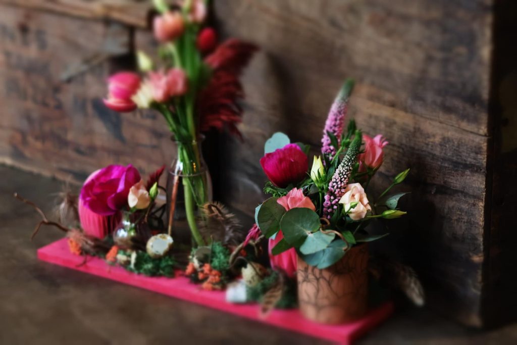 Une composition sur-mesure avec des fleurs roses et violettes sur fond en bois foncé
