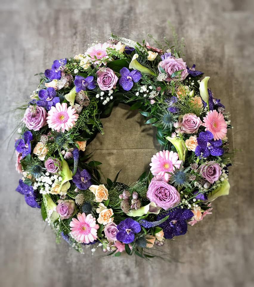 Une couronne de fleurs fraîches pour des condoléances avec des fleurs violettes et roses