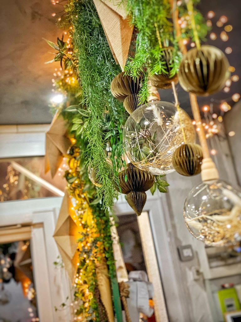 Décoration végétale suspendue composée de plantes, d'étoiles dorées et de boules de verre
