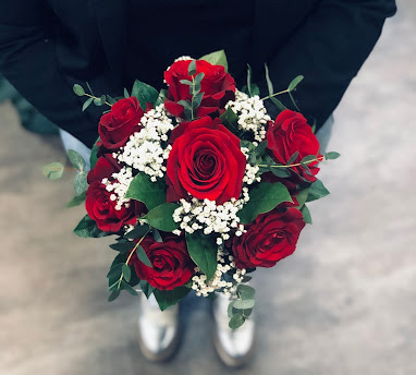Un magnifique bouquet de roses rouges et gypsophile blanc avec du feuillage vert, crée sur mesure par les fleuristes pour un mariage dans les Vosges