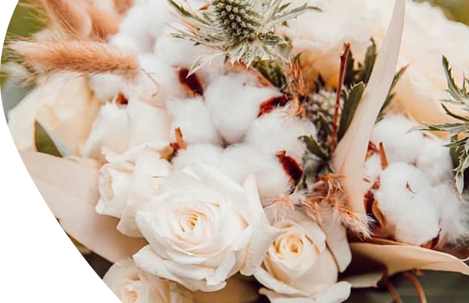 Bouquet composé de roses blanches, de chardon et de fleurs de coton