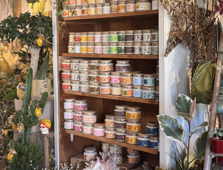 Un meuble dans la boutique qui contient les bougies artisanales vendues par les fleuristes