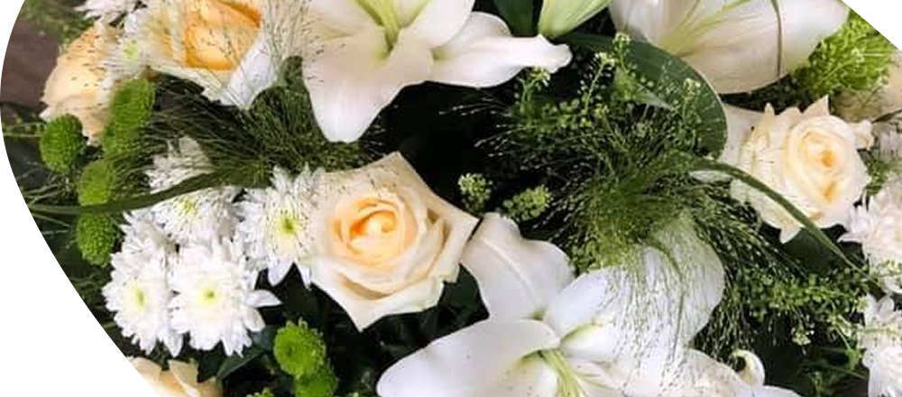 Une composition florale funéraire avec des fleurs de lys blanches