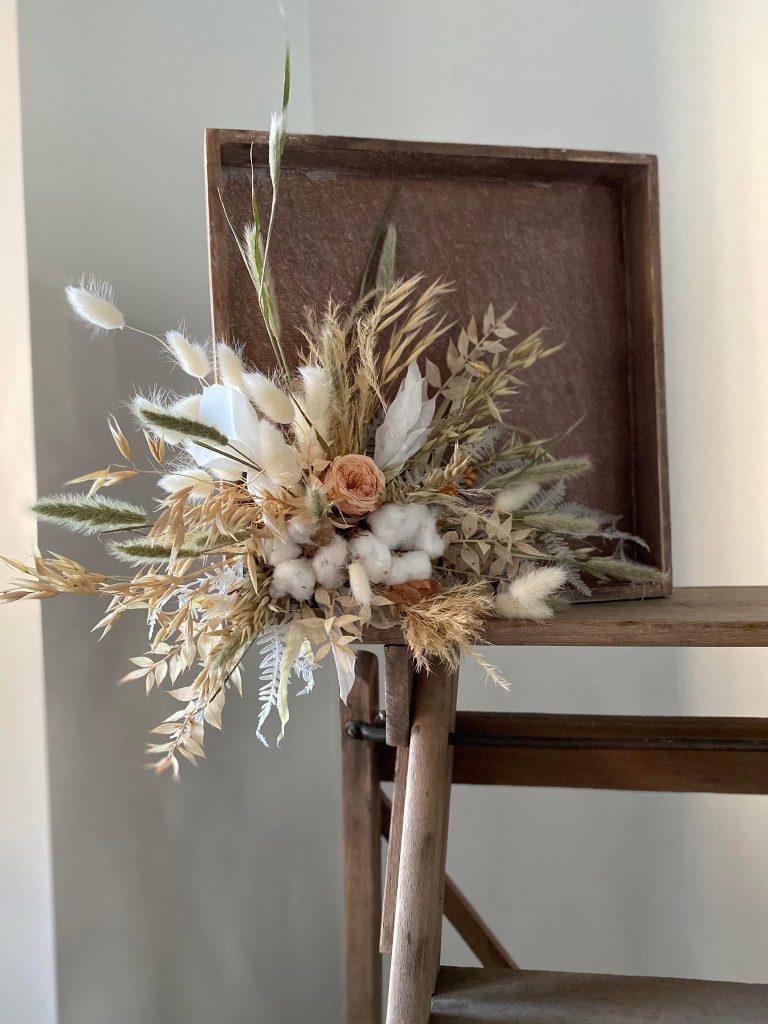Un cadre en bois décoré avec une composition en fleurs séchées