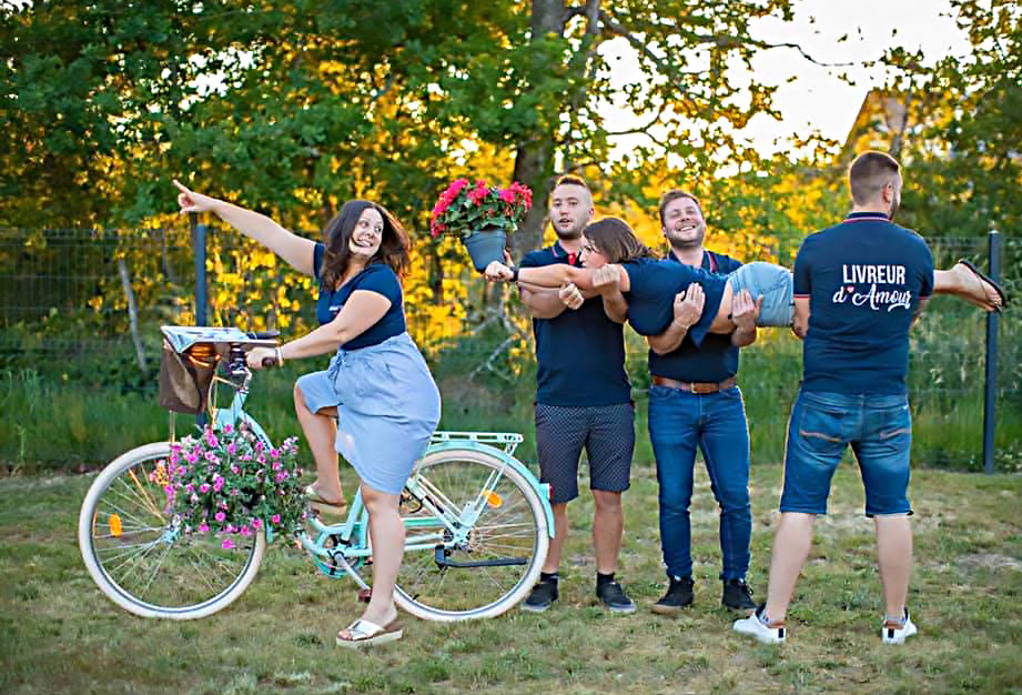 La fleuriste Pauline est sur un vélo, entourée de l'équipe de livraison dans une ambiance joyeuse