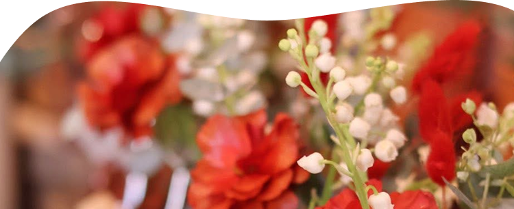 Zoom sur un bouquet de fleurs rouges avec du muguet blanc