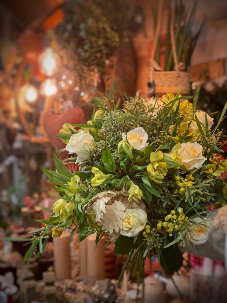 Un bouquet naturel dans les tons verts et blancs avec une lumière tamisé en fond