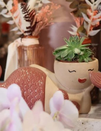 Petit pot de plante décoratif en forme de sirène dans la boutique des fleuristes à Arches