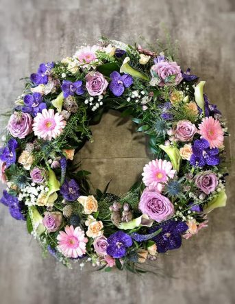 Une couronne de fleurs fraîches pour des condoléances avec des fleurs violettes et roses