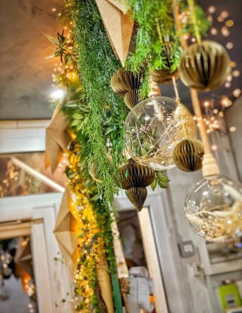 Décoration végétale suspendue composée de plantes, d'étoiles dorées et de boules de verre