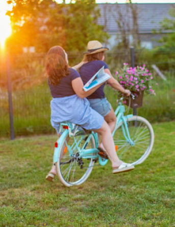 Les deux fleuristes sont dans l'herbe sur un vélo bleu avec des fleurs placées dans le panier au niveau du guidon