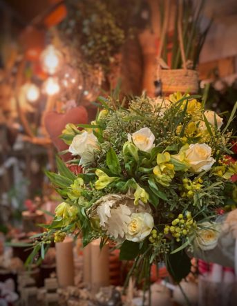 Un bouquet naturel dans les tons verts et blancs avec une lumière tamisé en fond
